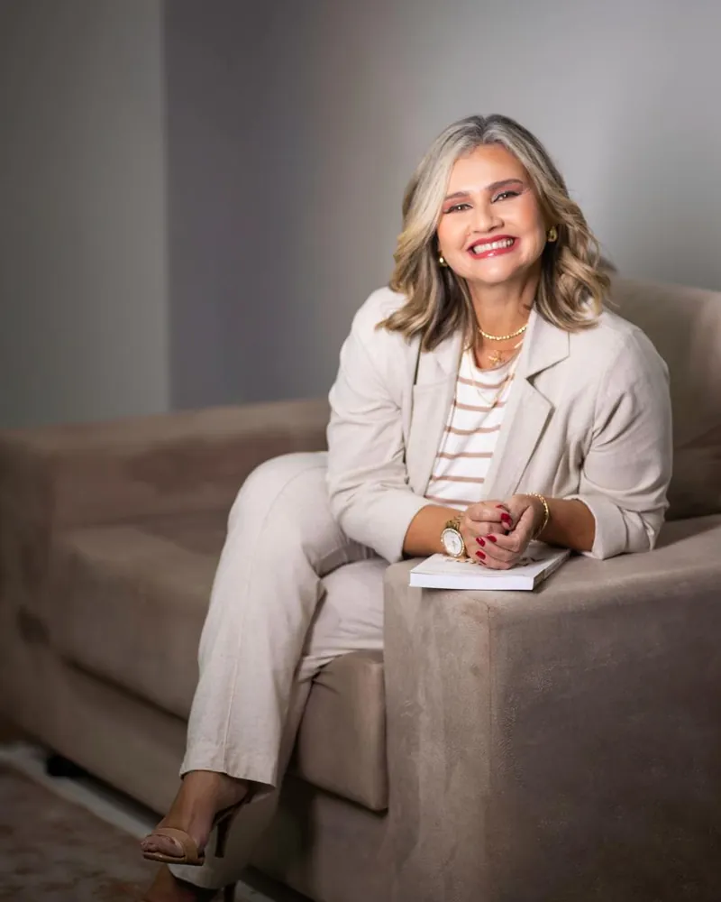 Adriana Gomes sorrindo no consultório da AG Psicologia em São Carlos
